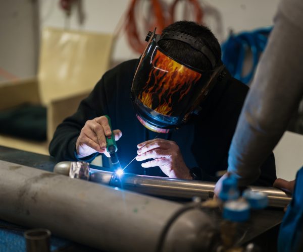 Man working with argon welding machine in a garage