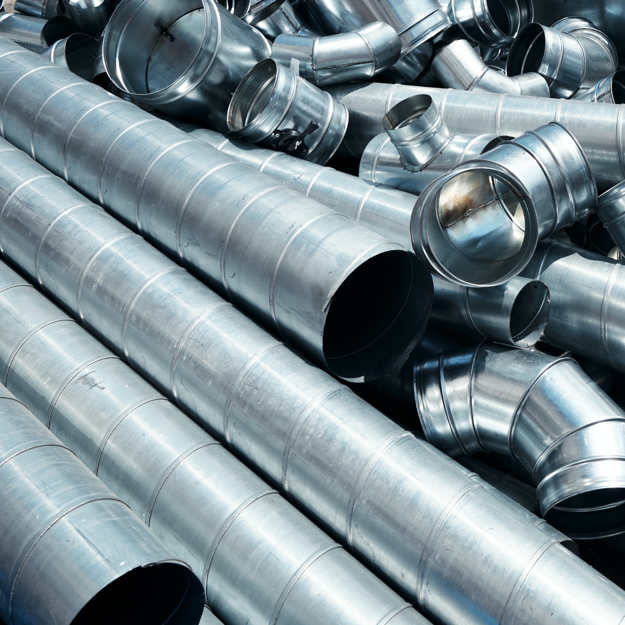 Pile of pipes and parts for duct systems. Industrial ventilation
